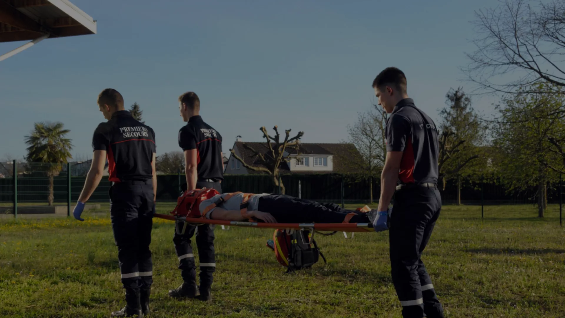 Trois secouristes bénévoles de l'UDPS 69 transportant une victime sur un brancard lors d'un exercice